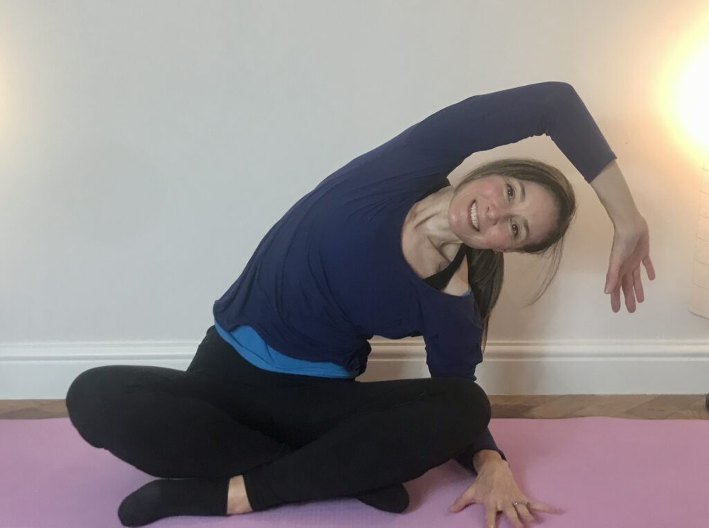 Name to a face Jo doing Pilates exercise seated side bend